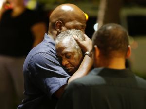 A Charleston community member comforts a man mourning news learned of nine Emanuel African Methodist Episcopal church members shot and killed during bible study on Wednesday night, June 17, 2015 in Charleston, S.C. Photo courtesy: Associated Press